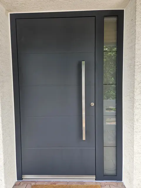 Anthrazitfarbene Haustür mit Glas-Seitenteil und Stangengriff