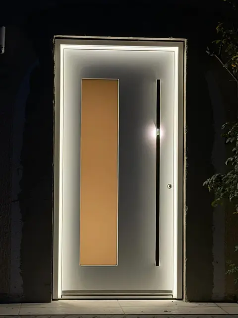 Haustür bei Nacht, von Licht umrahmt